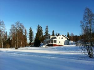 una casa blanca en la nieve frente a un patio en Villa Fridhem, Härnösand, en Härnösand