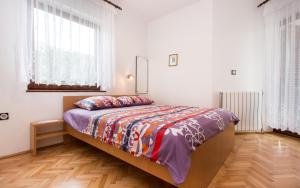 ein Schlafzimmer mit einem Bett in einem Zimmer mit Fenstern in der Unterkunft Apartments Lucija in Baška