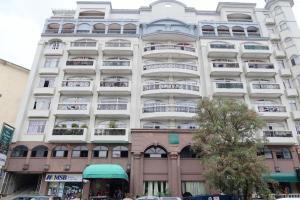 a large white building with balconies on a street at Burnham Place Leisure Stay Unit 1 in Baguio