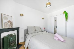 a white bedroom with a bed and a fireplace at Magnifique appart rénové La Défense Paris Gare 2Pers in Nanterre