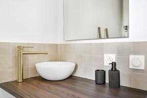 a bathroom with a white tub and a sink at Magnifique appart rénové La Défense Paris Gare 2Pers in Nanterre +10 photos