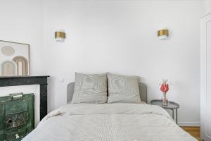 a white bedroom with a bed and a fireplace at Magnifique appart rénové La Défense Paris Gare 2Pers in Nanterre