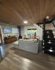Green Valley LakeにあるThe Honey Bear Cabin Jacuzzi EV Friendly Renovatedのソファと階段のあるリビングルーム
