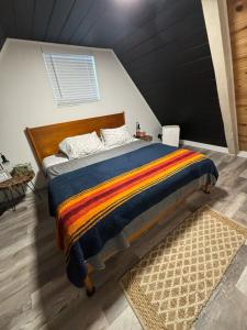 Green Valley LakeにあるThe Honey Bear Cabin Jacuzzi EV Friendly Renovatedの黒い壁のベッドルーム1室(ベッド1台付)