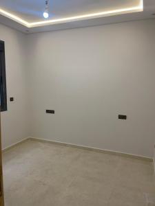ein leeres Zimmer mit weißen Wänden und Fliesenboden in der Unterkunft Saidia in Oulad Akkou