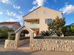 a house with a stone fence and a stone wall at Apartments with parking space Korcula - 180 in Korčula