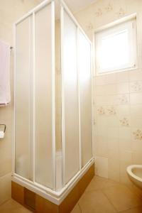 a shower in a bathroom with a window and a sink at Apartments with parking space Korcula - 180 in Korčula +15 photos