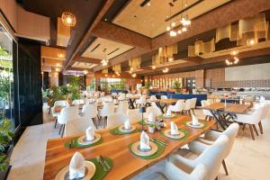 un ristorante con tavoli in legno e sedie bianche di Luani-A spa & wellness center a Shkodër