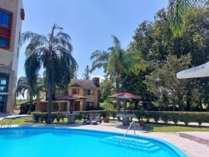 a swimming pool in front of a house at GB Hotel in Montemorelos