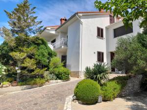 a large white house with a driveway at Apartments with parking space Banjol, Rab - 16334 in Rab