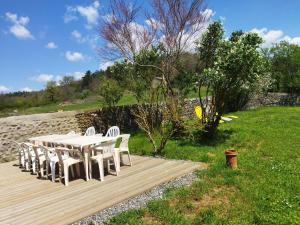 a white table and chairs on a wooden deck at Maison de Charme à Domeyrat: Jardin, Balades, Confort et Animations Culturelles - FR-1-582-334 in Domeyrat