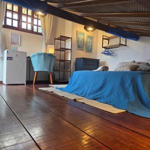a bedroom with a bed and a wooden floor at Recanto das Borboletas in Búzios