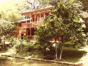 a wooden house with a tree in front of it at hotel campestre san antonio in Campoalegre
