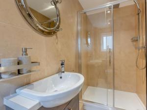 a bathroom with a white sink and a shower at 3 Bed in Westward Ho 65536 in Westward Ho +4 photos