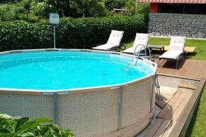 a swimming pool with two chairs and a table at Family-friendly apartments with swimming pool Lic, Gorski kotar - 23685 in Fužine