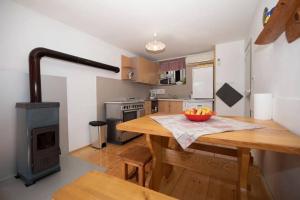 a kitchen with a wooden table with a bowl of fruit at Family-friendly apartments with swimming pool Lic, Gorski kotar - 23685 in Fužine