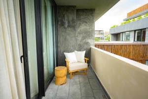 a balcony with a white chair and a window at Jungle Sunset Penthouse in Tulum with Private Pool, 5 Min from Beach in Tulum