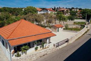 ein orangefarbenes Dach auf einem Gebäude mit einer Straße in der Unterkunft Holiday house with a parking space Imotski, Zagora - 24482 in Imotski