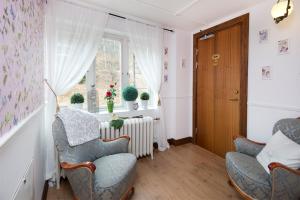 a living room with two chairs and a window at Hotell Aina in Kvissleby