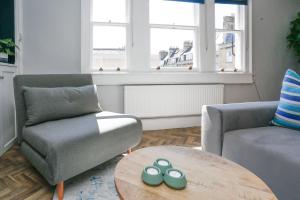 a living room with a chair and a table at Top Floor at 13 Rivers Street in Bath