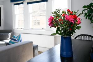 a blue vase with flowers sitting on a table at Top Floor at 13 Rivers Street in Bath +24 photos