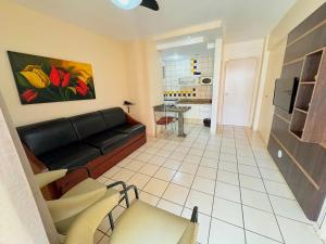 a living room with a black couch and a kitchen at Apartamentos Eldorado Thermas Park in Caldas Novas