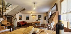 a table with a bottle of wine and a wine glass at Ballabio Lake - Rustic Chic Retreat in Ballabio