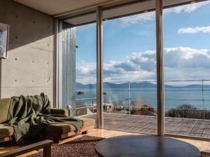 a living room with a couch and a large window at 牛窓villa-オーシャンビューヴィラ ペット同伴 バーベキュー可 in Kashino