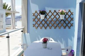 a white table and chairs on a balcony with flowers at Residencial Jandía Marina in Morro del Jable