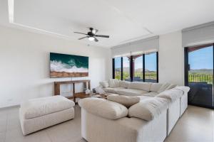 Una sala de estar con dos sofás y un ventilador de techo. en Bougainvillea 4315 Ph- Luxury 3 Bedroom Ocean View Resort Condo, en Brasilito