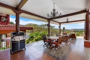 Un patio con mesa y sillas y una estufa. en Bougainvillea 4315 Ph- Luxury 3 Bedroom Ocean View Resort Condo, en Brasilito