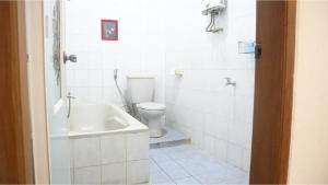 a white bathroom with a toilet and a sink at PLUM Hotel Palereman Batu in Batu +57 photos
