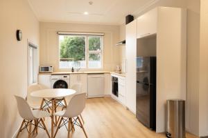 a kitchen with a small table and chairs in a room at Central Kaikōura Stay Unit 1 in Kaikoura