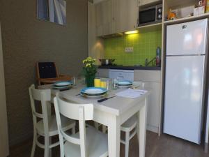 a kitchen with a white table and a white refrigerator at Gîte in Normandy near Sandy Beach in Port-Bail-sur-Mer +13 photos