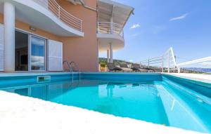 a swimming pool in front of a house at 2 Bedroom Amazing Apartment In Lukovo in Lukovo