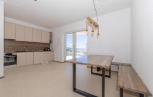 a kitchen with a wooden table and a bench at 2 Bedroom Amazing Apartment In Lukovo in Lukovo