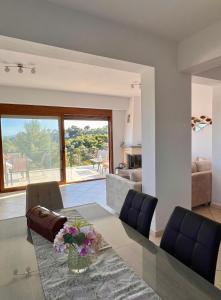 a dining room with a glass table and blue chairs at Golden Sunset Villa Skiathos in Skiathos Town +32 photos
