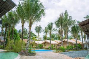 a resort with a pool and palm trees at Canopy Villa Cay Sao in Phu Quoc