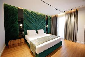 a bedroom with a bed with a green wall at Luani-A spa & wellness center in Shkodër +81 photos