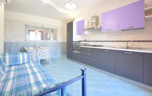 a kitchen with purple cabinets and a sink and a table at Il Giardino Dei Filosofi in Ascea