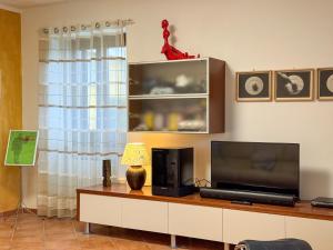 a living room with a tv and a table with a lamp at Casa dello Psiconauta - Atelier con giardino mediterraneo in San Vito Chietino +33 photos