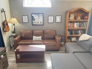 ein Wohnzimmer mit einem braunen Sofa und einem Bücherregal in der Unterkunft DT 323 Kessler Cottage in New Braunfels