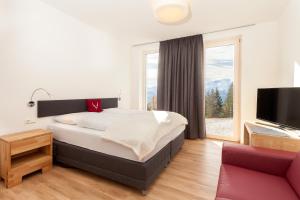 ein Schlafzimmer mit einem großen Bett und einem großen Fenster in der Unterkunft Schmiedhof Alm in Zell am See