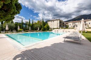 托斯科拉诺-马德尔诺Corte Fasanella appartamento Lillà的配有椅子和遮阳伞的大型游泳池