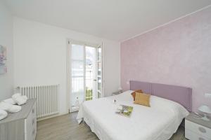 托斯科拉诺-马德尔诺Corte Fasanella appartamento Lillà的一间带大床和窗户的白色卧室