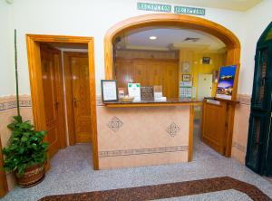a hotel room with a reception counter and an archway at Hostal Los Corchos in Fuengirola