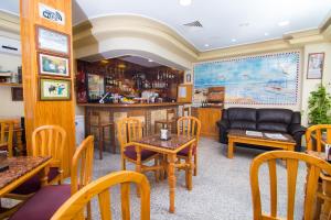 a restaurant with tables and chairs and a bar at Hostal Los Corchos in Fuengirola