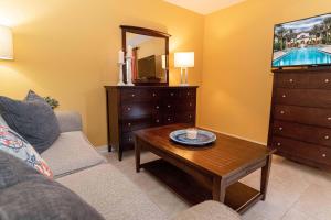 a living room with a couch and a tv and a table at Luxurious-amazing Pool View from balcony 5216LP in Saint Augustine