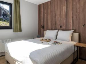 a bedroom with a large white bed with a wooden headboard at Villa in Belgium with Private Terrace in La Roche-en-Ardenne