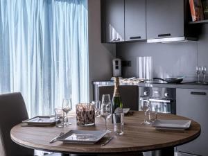 a wooden table with glasses and a bottle of wine at Villa in Belgium with Private Terrace in La Roche-en-Ardenne